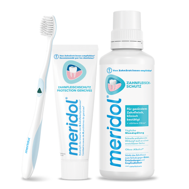 Flaschen von meridol med Mundspülung (CHX 0,2%) und eine weiße Zahnbürste mit blauen Borsten.